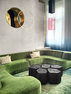 couch - Scenography by Charles Zana. built-in brass & concrete sculptural wall,  organic coffee table, green couch