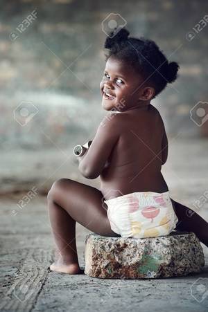 baby black girl nude - Portrait of naked black african baby in diaper laughing at camera in rural  area Stock Photo