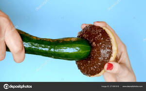 Cucumber Porn 2000 - The concept of a healthy diet and diet. chocolate donut against green  cucumber. Fun fast food project Stock Photo by Â©kopitin 271991918