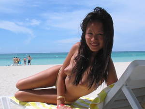 natural beach topless - Topless beach girl exposes her natural asian titties with smile on her  pretty face
