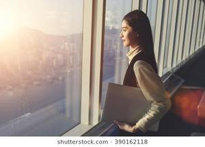 ebony big natural tits standing in front of window - Young woman candidate is holding laptop computer, while standing in office  interior and looking out
