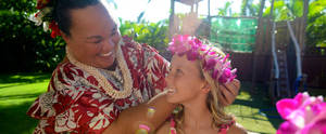 Hawaiian Girl Birthday Porn - A smiling woman in Hawaiian garb puts a fuchsia orchid wreath on a young  girl's head ...