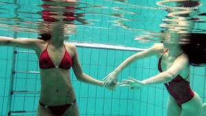 lesbians swimsuit undressing - Two skinny and fresh white girls in red bikini undress in the pool