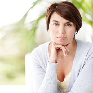 asian clit 1 2 3 - A middle-aged woman sits with her chin on her hand.