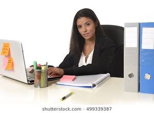 Hispanic Businesswoman Porn - corporate portrait of young attractive hispanic businesswoman sitting at  office desk working on computer laptop smiling