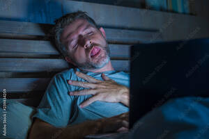 Facial Sleeping - man alone in bed playing cybersex using laptop computer watching porn sex  movie late at night with lascivious pervert face expression in internet  pornographic sexual content Stock Photo | Adobe Stock