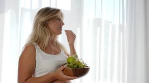 eating pregnant belly nude - healthy pregnancy, pregnant female with big naked tummy eats grapes and  holds wooden plate with