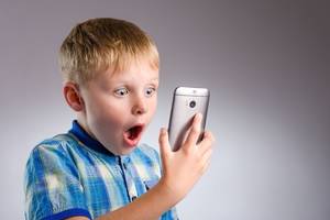 Homemade Toddler - Young boy looking shocked with smartphone.