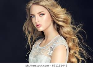 light haired cute student - Blonde fashion girl with long and shiny curly hair . Beautiful model in  light blue dress
