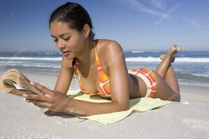 naked tanning beach bikini - Young woman in retro swimwear lies on beach reading a book Stock Photo by  Â©londondeposit 33989087
