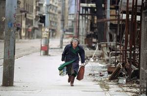 Bosnian Street - A Bosnian woman rushes down an empty sidewalk past war-destroyed shops in  one of the worst sections of the so-called 'Sniper Alley. April 8, 1993 in  Sarajevo. [991x648] : r/HistoryPorn