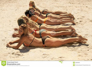 bikini on beach laying down - Several girls in bikini lying on sandy beach