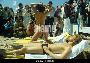 cannes beach topless - Cannes Film Festival semi nude woman topless on beach with boyfriend. Pose  amateur and press photographers at work working. 1980s France HOMER SYKES  Stock Photo - Alamy