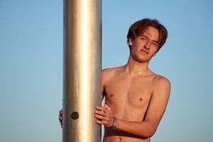 cute teen nudists - Premium Photo | A closeup of the young man taking a shower on the beach.
