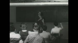 Black Internet - UNITED STATES, 1950s: Man teaches class at blackboard. Student writes on  blackboard.