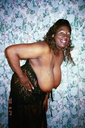 black mom heavy tits - Fat mom with huge heavy melons strips nude and poses with smile on her face