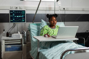 black funny videos - African american sick patient standing in bed during medical appointment  watching online funny videos on laptop computer. Young woman recovering  after surgery in hospital ward. Medicine services Photos | Adobe Stock