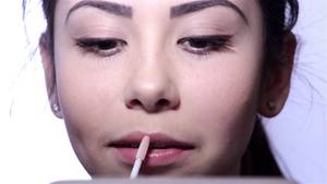 Beautiful Young Girl Solo - Young woman doing makeup in front of a mirror, full face, blurred  background.