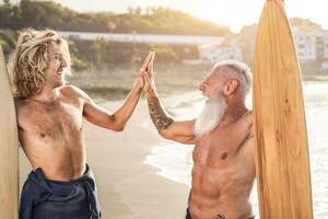 beach senior trip nude - Premium Photo | Multi generational surfer friends hands five on the beach  after surf session - focus on senior man face