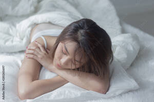 free sleeping porn galleries - Asian girl sleeping naked with a slim body In a white bed opposite the  window in the house, soft light Stock Photo | Adobe Stock