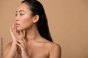 asian beautiful face nude - beautiful naked asian girl looking away and touching face isolated on beige  Stock Photo | Adobe Stock