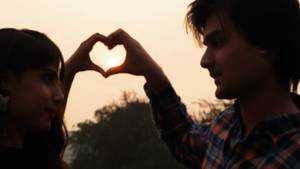 indian couple holding hands - 4k00:20An Indian couple looking deep into each others eyes while encircling  the setting sun in a heart shaped formation with hands in New Delhi, India