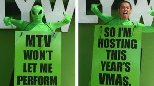 Miley Cyrus Schoolgirl Porn - Miley Cyrus dressed as an alien wearing a sandwich board