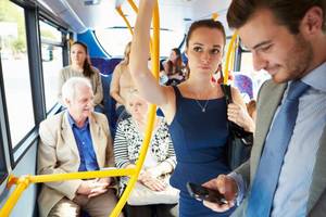 Bbc Public Porn - A man looks at his mobile phone on a bus. A woman looks disapproving,