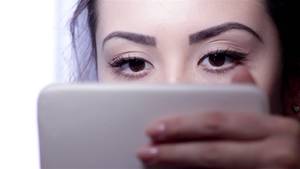 Beautiful Young Girl Solo - Young woman doing makeup in front of a mirror, full face, blurred  background.