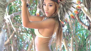 dance native american indians nude - Sensual Native American Indian looking woman wearing nude bikini and indian  feather hat standing between tropical