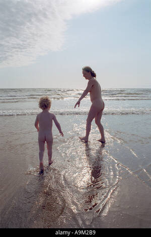 naturist nudist mom - mother and son going for a nude swim in the sea by Aberdyfy Aberdovey North  West Wales Stock Photo - Alamy