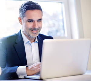 naturist beach erections and girls - Man smiling at laptop