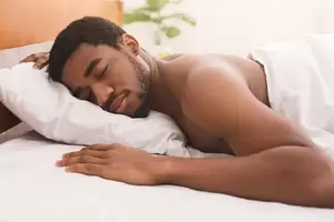 homemade sleeping nudes - Naked black man sleeping in bed at home Stock Photo | Adobe Stock