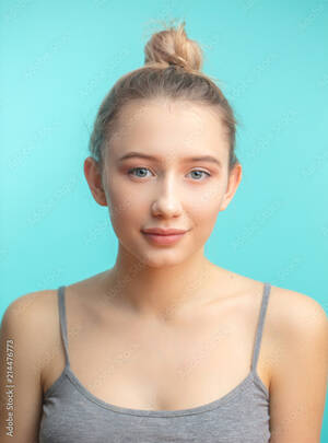 fresh teen girls - Attractive caucasian teenager girl with nude makeup, natural expressive  lips, perfect fresh skin posing isolated over blue studio background. Blond  hair tied in bun. Youth and Skin Care Concept. Stock Photo |