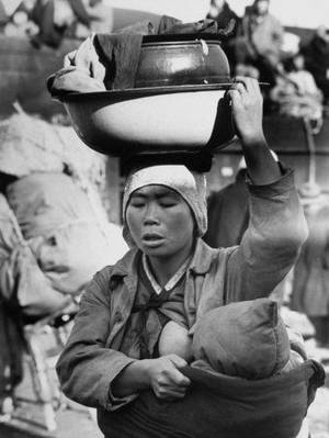 breastfeeding in the 50s - Breastfeeding her baby with one hand while balancing a huge load of work  with the other. the strength of a mother