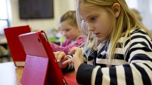 Cheerleader Porn Elementry - Two young girls sit at a desk with iPads.